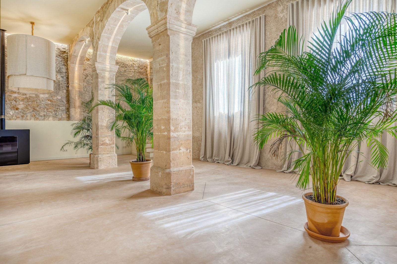 Sala de arcos de marès de Can Rey Petra, con muros de piedra y luz natural